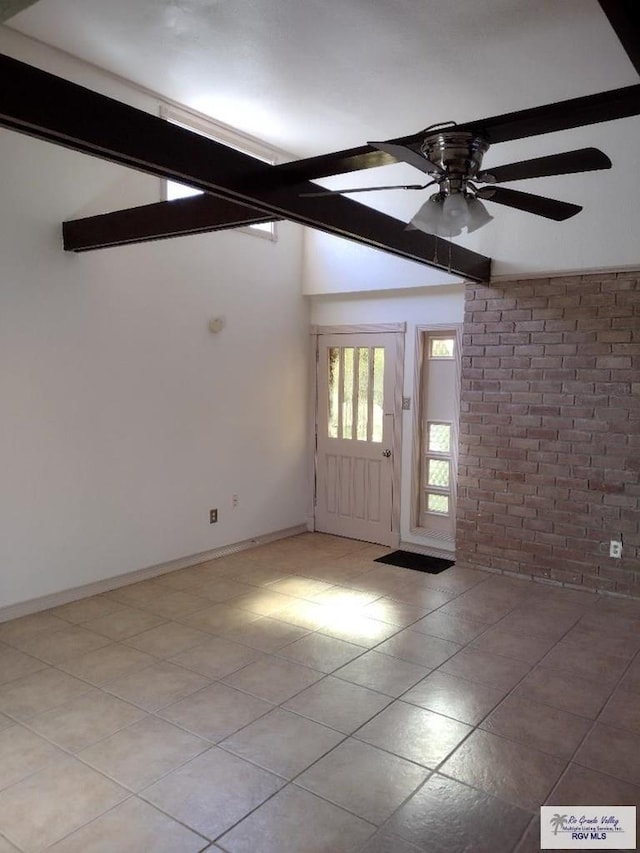 interior space featuring beamed ceiling, ceiling fan, and brick wall