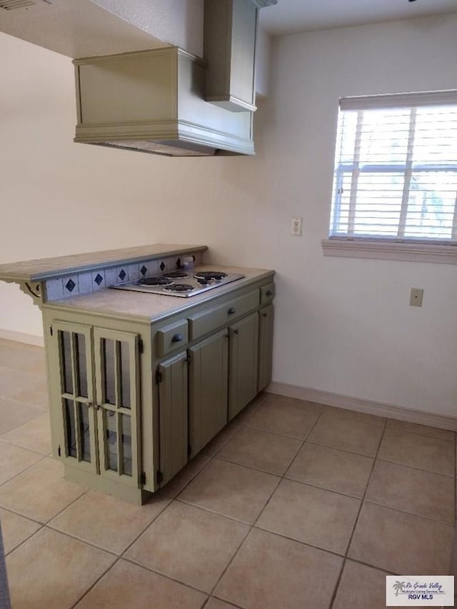 kitchen with gray cabinets, white gas cooktop, and light tile patterned flooring