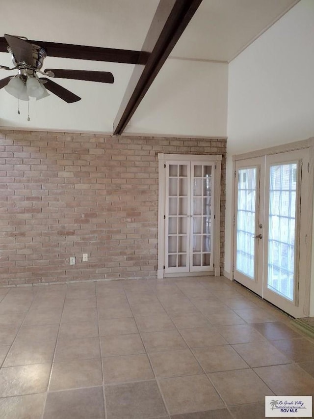 spare room with french doors, brick wall, ceiling fan, light tile patterned floors, and beamed ceiling