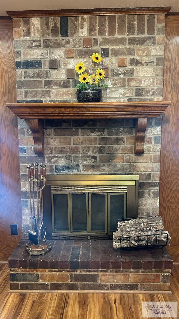 interior details with hardwood / wood-style floors and a brick fireplace