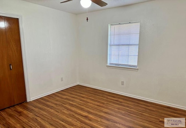 spare room with ceiling fan and dark hardwood / wood-style flooring