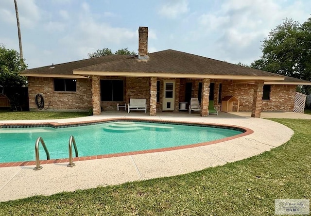 view of pool featuring a yard and a patio