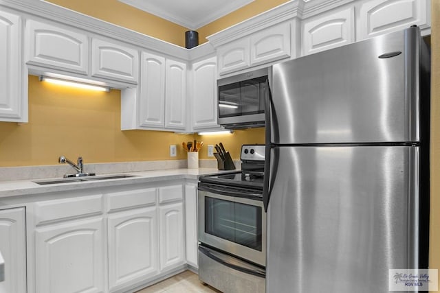 129 E Cora Lee Dr Unit 205, South Padre Island, TX 78597 - kitchen featuring crown molding, white cabinets, a sink, stainless steel appliances, and light countertops
