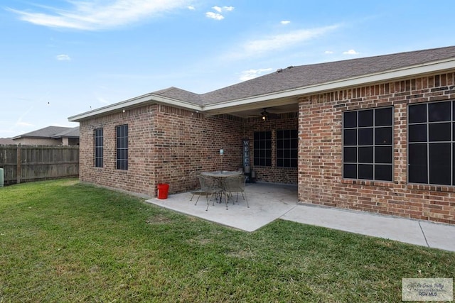 back of property featuring a lawn, ceiling fan, and a patio area