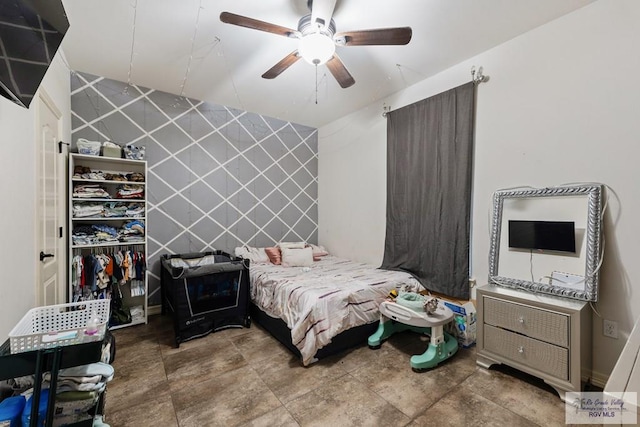 bedroom featuring ceiling fan and tile walls