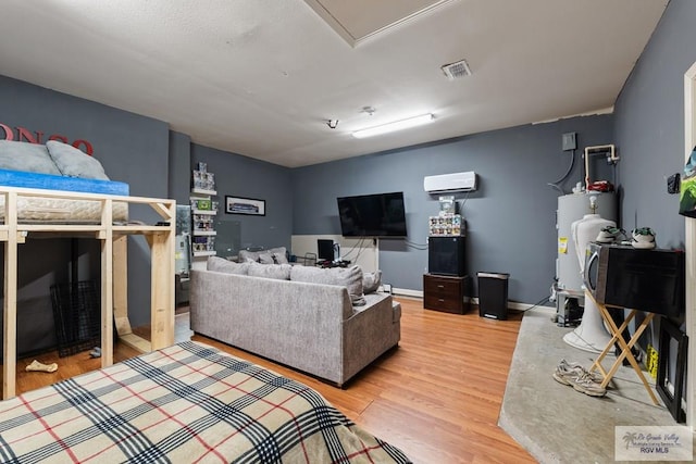 bedroom featuring a wall mounted air conditioner, hardwood / wood-style floors, and water heater