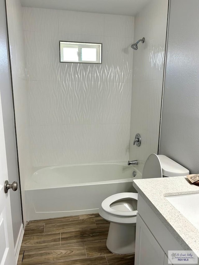 full bathroom featuring hardwood / wood-style floors, vanity, tub / shower combination, and toilet