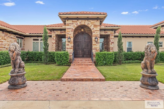 mediterranean / spanish home featuring a front yard