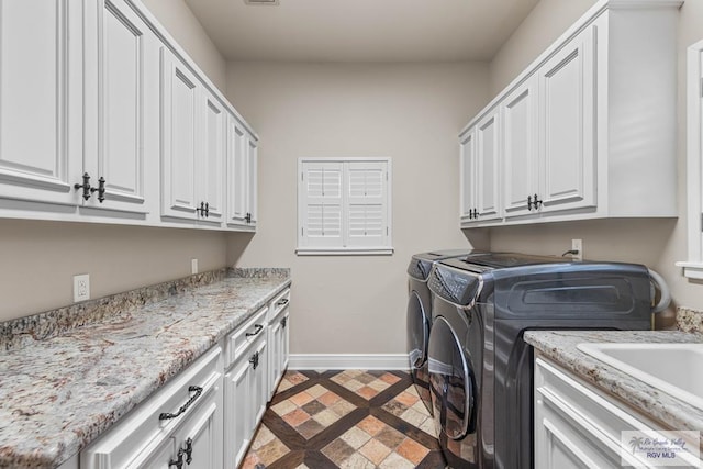 laundry room with cabinets and washing machine and clothes dryer