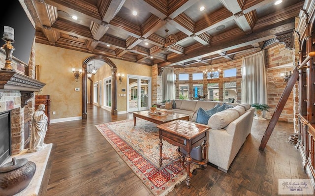 living room with dark hardwood / wood-style flooring, a fireplace, and beamed ceiling