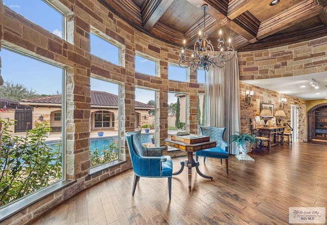 sunroom with beamed ceiling, coffered ceiling, and a notable chandelier