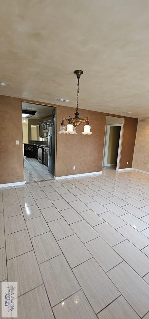 1626 N Shore Dr, Port Isabel, TX 78578 - unfurnished room with a chandelier, baseboards, and light tile patterned floors