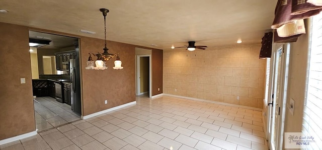 1626 N Shore Dr, Port Isabel, TX 78578 - unfurnished room with a ceiling fan, light tile patterned floors, a chandelier, and baseboards
