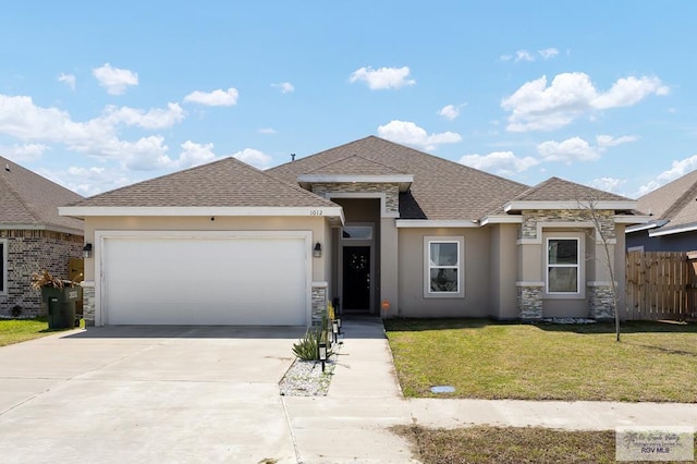 prairie-style house with a garage, fence, driveway, stucco siding, and a front lawn