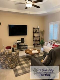 living room featuring ceiling fan, wood-type flooring, and a tray ceiling