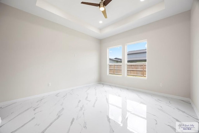 5359 Sidekick Ave, Brownsville, TX 78526 - spare room featuring a raised ceiling, marble look tile flooring, a ceiling fan, and recessed lighting