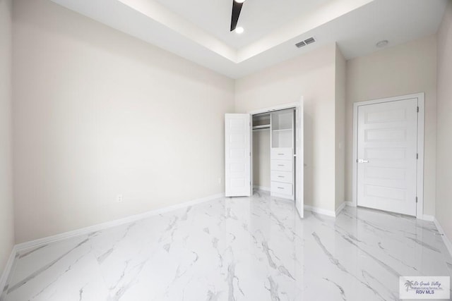 5359 Sidekick Ave, Brownsville, TX 78526 - unfurnished bedroom featuring light marble finish flooring, a closet, a ceiling fan, and a raised ceiling