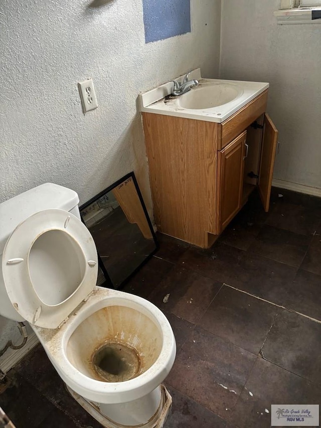 821 Virginia Ave, La Feria, TX 78559 - half bathroom featuring vanity and a textured wall