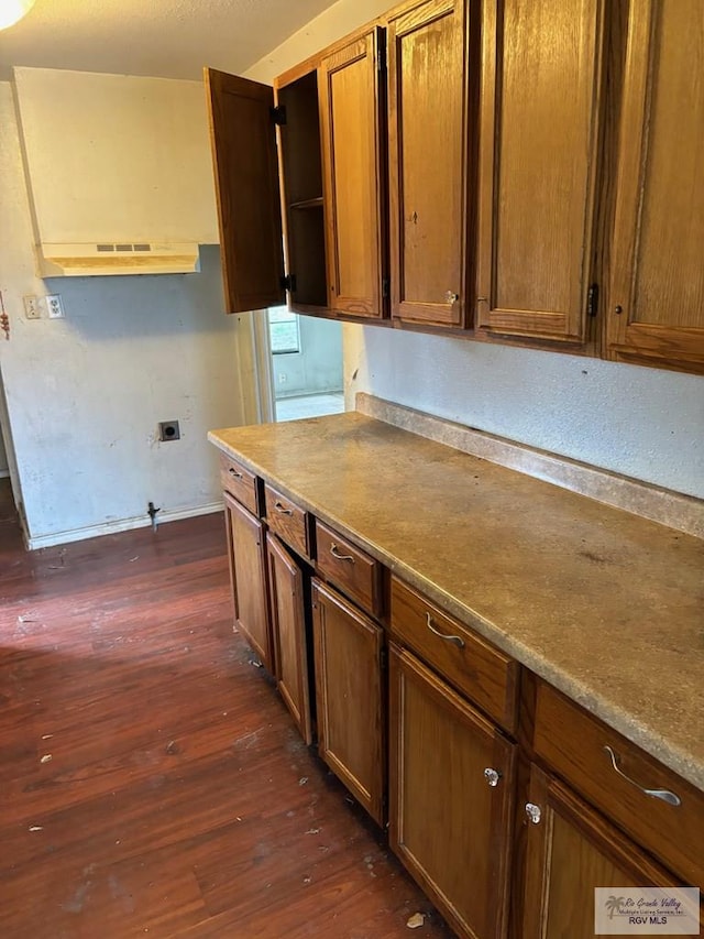 821 Virginia Ave, La Feria, TX 78559 - kitchen with dark wood finished floors, open shelves, brown cabinetry, and under cabinet range hood