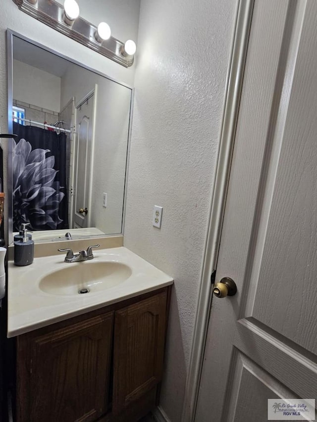 2884 Gibraltar St, Brownsville, TX 78520 - full bath with vanity, a textured wall, and a shower with shower curtain