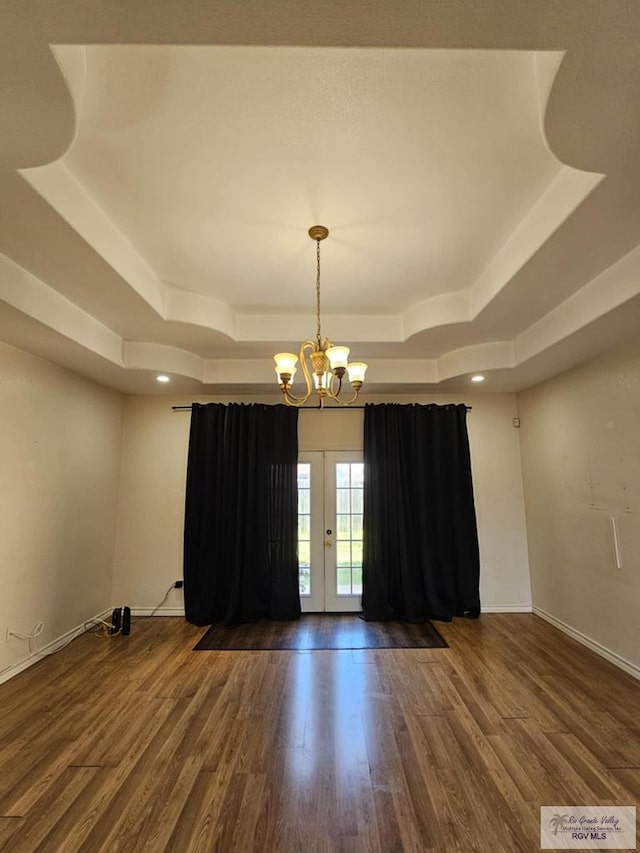 2884 Gibraltar St, Brownsville, TX 78520 - empty room featuring a raised ceiling, french doors, wood finished floors, a chandelier, and baseboards