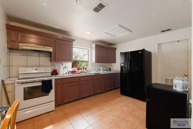 kitchen featuring decorative backsplash, black fridge, white range with electric stovetop, sink, and light tile patterned floors