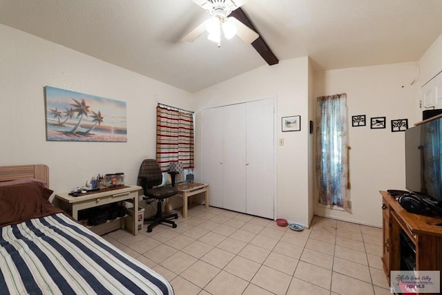 tiled bedroom with ceiling fan, lofted ceiling with beams, and a closet