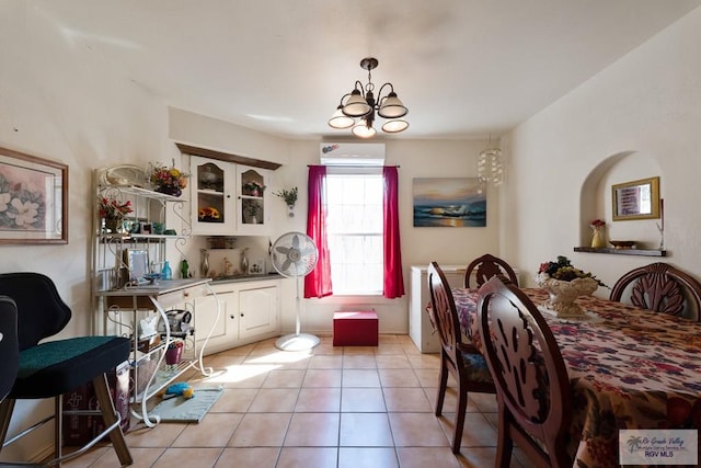 tiled dining area with a chandelier and a wall mounted AC