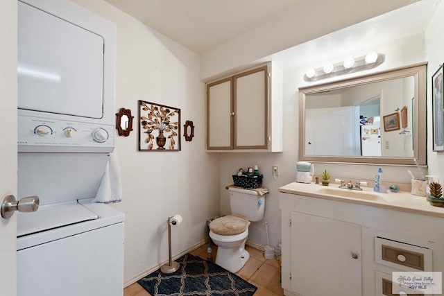 bathroom featuring tile patterned floors, stacked washer and dryer, vanity, and toilet