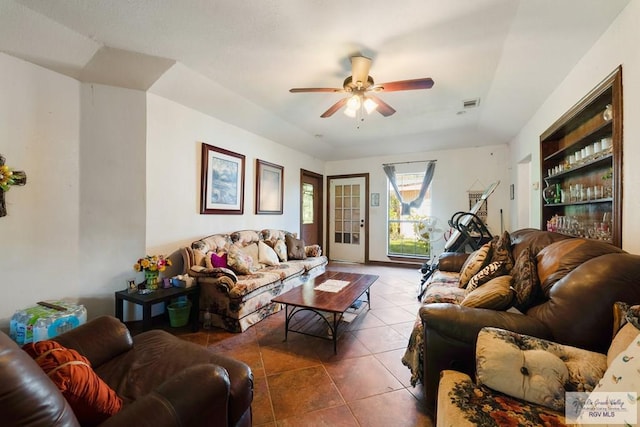 living room featuring ceiling fan and dark tile patterned floors