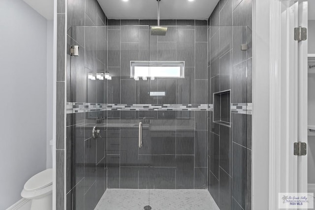 bathroom with a shower with door and toilet