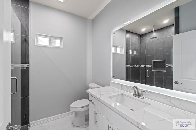 bathroom with vanity, a shower with door, toilet, and a healthy amount of sunlight