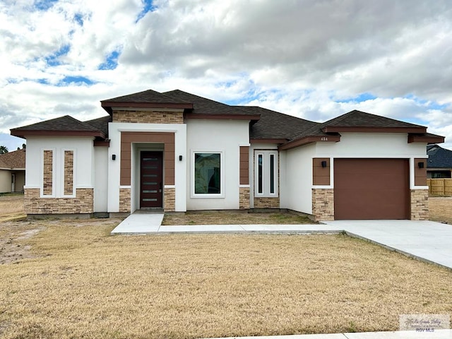 prairie-style home with a garage and a front yard