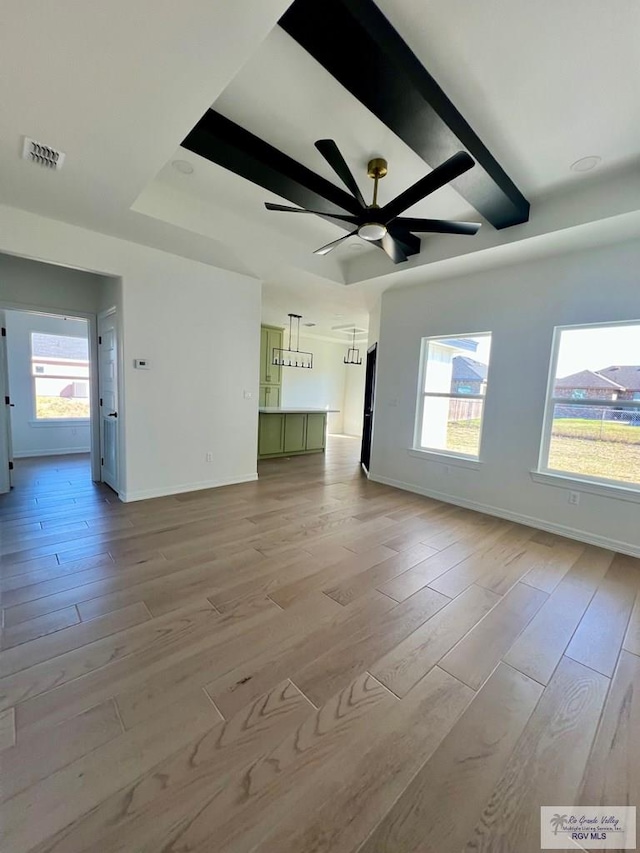 unfurnished living room featuring light wood-style floors, plenty of natural light, and visible vents