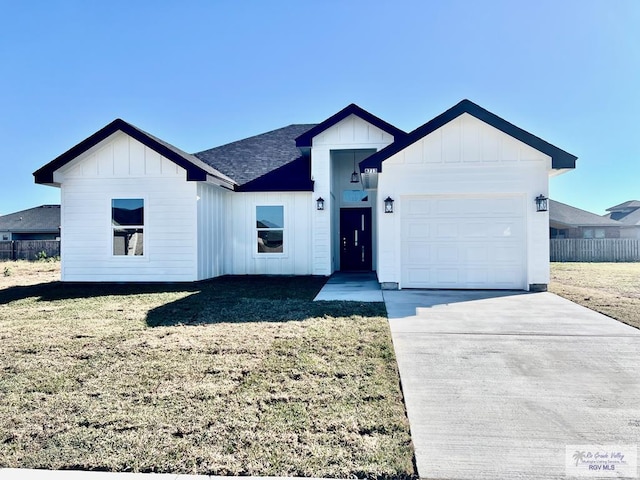 modern farmhouse style home with roof with shingles, concrete driveway, board and batten siding, a front yard, and a garage