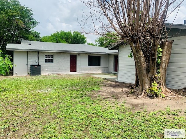 1218 S 16th St, Harlingen, TX 78550 - rear view of property with a yard and brick siding