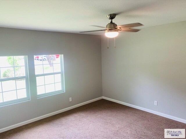 carpeted spare room with ceiling fan