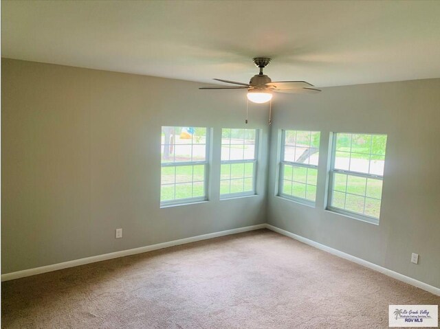 carpeted empty room featuring plenty of natural light and ceiling fan