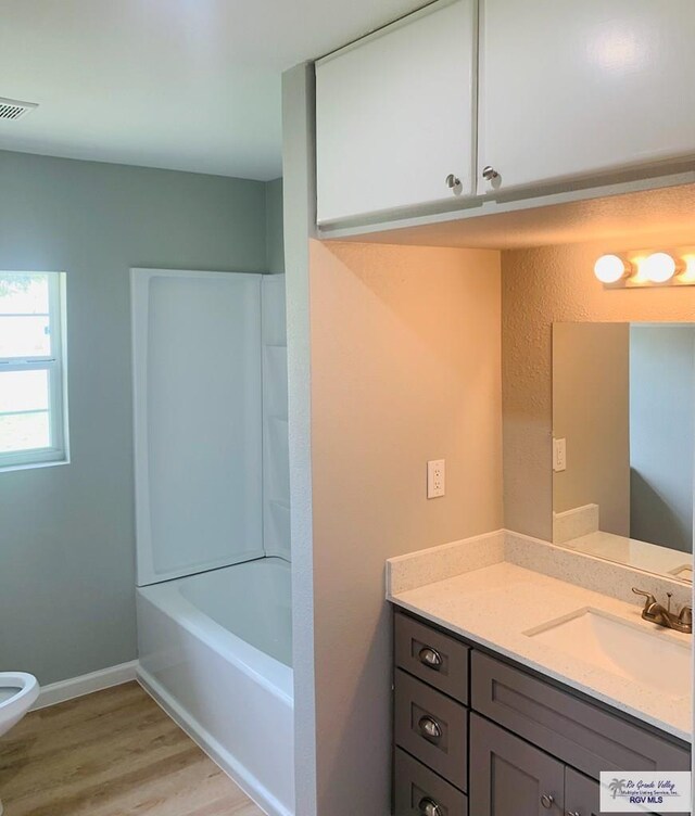 bathroom featuring shower / bathing tub combination, wood-type flooring, and vanity