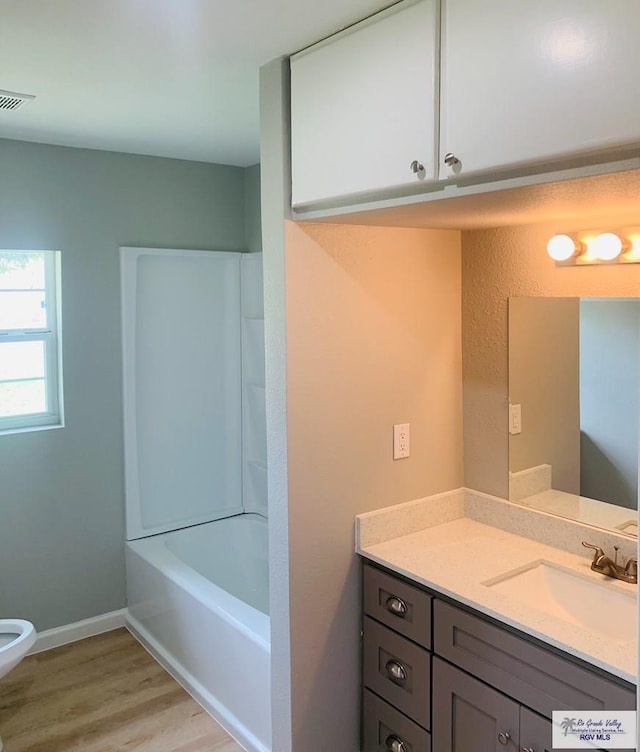 1218 S 16th St, Harlingen, TX 78550 - full bath featuring vanity, wood finished floors, and bathing tub / shower combination