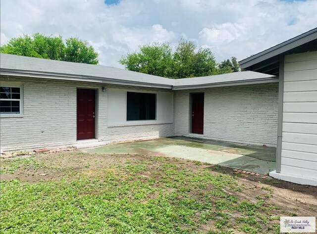 view of exterior entry with a patio area