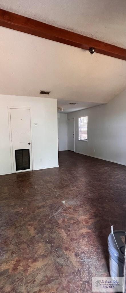 unfurnished living room featuring vaulted ceiling with beams