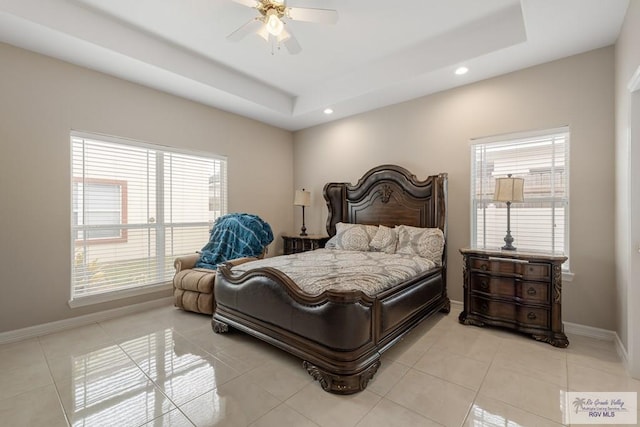 bedroom with a tray ceiling, ceiling fan, and light tile patterned flooring