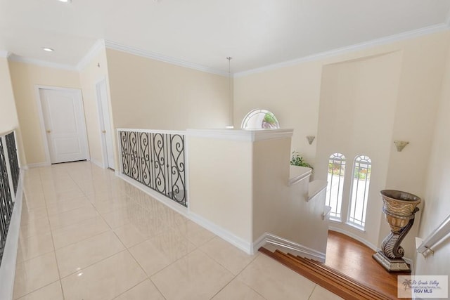 hallway with light tile patterned flooring and crown molding