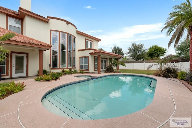 view of swimming pool featuring a patio area and an in ground hot tub