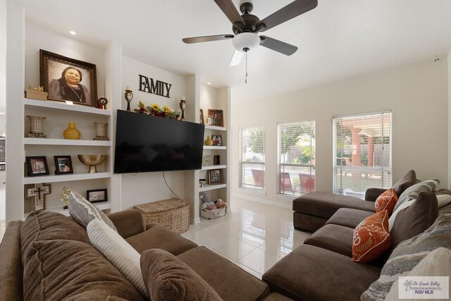 tiled living room with built in features and ceiling fan