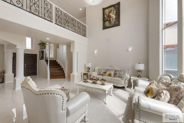 living room featuring decorative columns and a towering ceiling