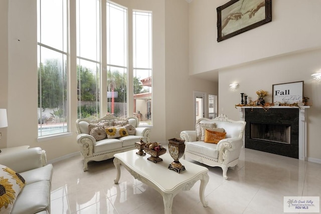 interior space featuring a high end fireplace, a towering ceiling, and light tile patterned flooring