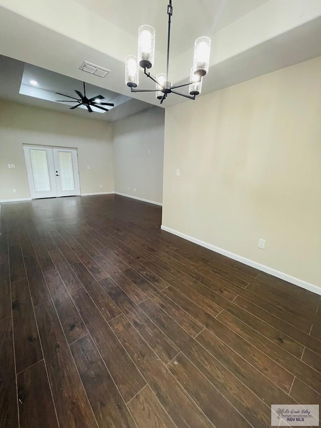 interior space with ceiling fan with notable chandelier and dark hardwood / wood-style flooring