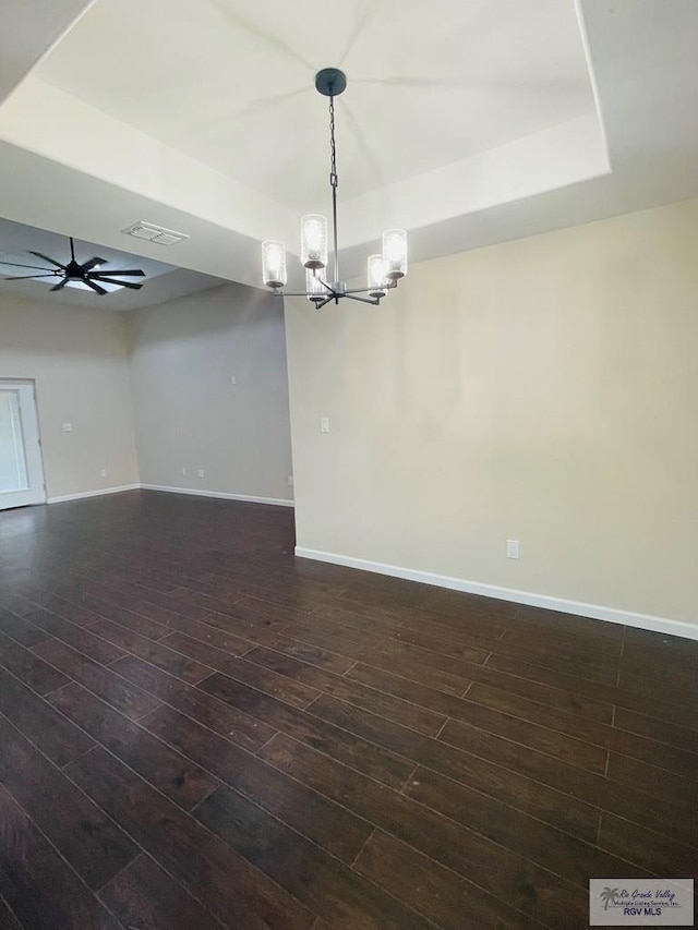 unfurnished room with ceiling fan with notable chandelier and dark hardwood / wood-style floors